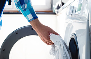 Person putting clothes in dryer